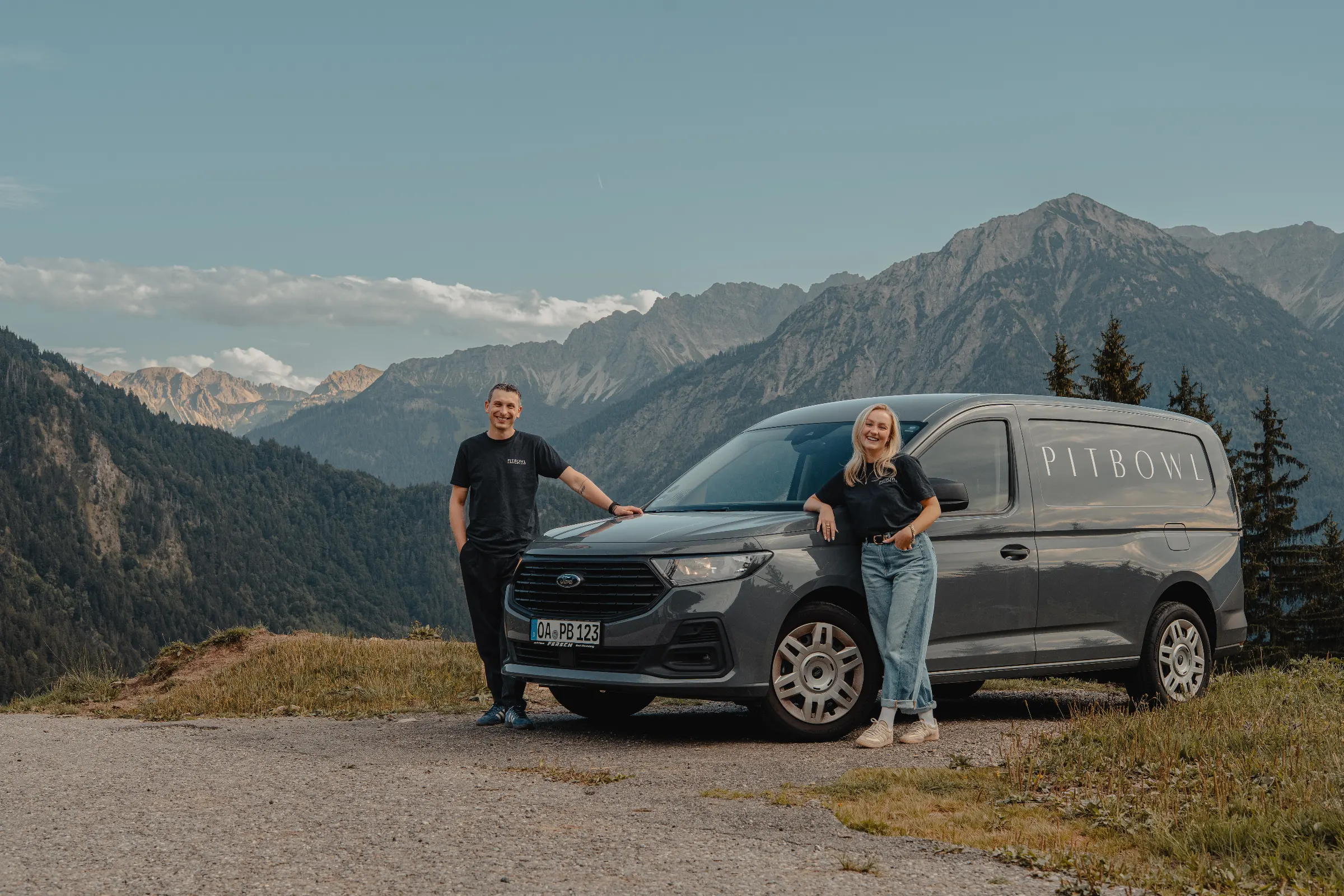 David und Anna lehnen an ihrem Ford Transporter