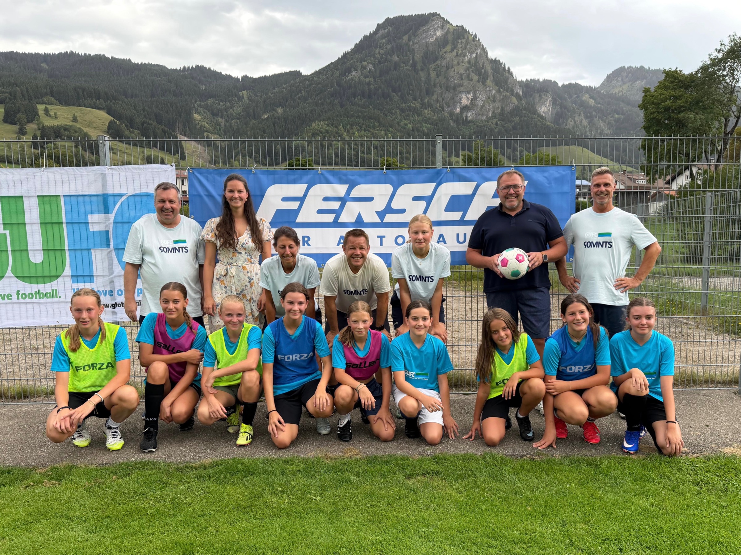 Teilnehmerinnen des Girlscamp mit Sponsoren und Trainerteam vor Logo Banner